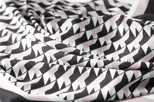 Macro detail of silky geometric pattern fabric with black, white and pink triangles