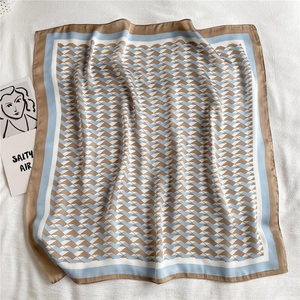 Close-up of geometric silk-like square scarf with blue and khaki zigzag pattern