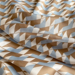 Close-up of geometric pattern on premium silk-like fabric with blue and brown hues