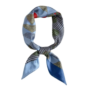 Blue silk scarf with yellow paisley, red dots and houndstooth pattern in a knot