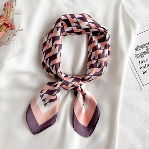 Elegant geometric faux silk scarf in pink and purple tones tied in a decorative bow knot