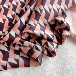 Detailed macro view of geometric patterned satin scarf with pink and purple houndstooth texture