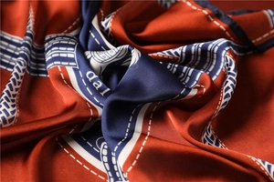 Macro shot of silk satin scarf with vintage orange and navy geometric print texture