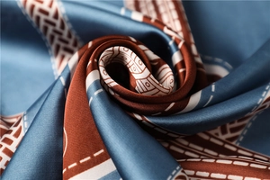 Macro shot of silky satin scarf with vintage geometric patterns in brown and blue