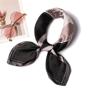 Detail of silk scarf featuring classic horse motif and geometric border patterns