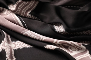 Macro shot of smooth black satin scarf with pink geometric prints and silky texture