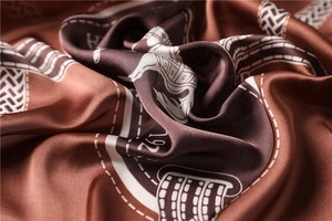 Macro detail of silk square scarf featuring vintage geometric patterns and smooth texture