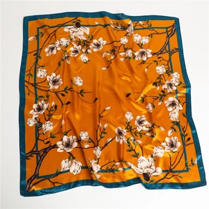 Vue détaillée de la texture soie avec motifs de magnolias et tissu orange élégant