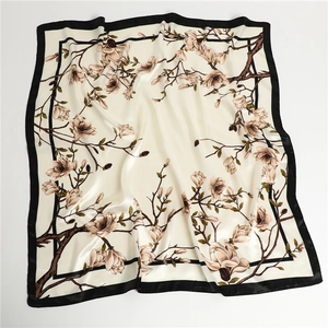 Détail d'un carré de soie avec des fleurs de magnolia réalistes et des bordures noires