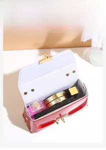 Detail view of red patent leather mini bag showing interior space for cosmetics