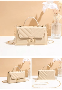 Macro detail of cream quilted shoulder bag with gold metal buckle and chain strap