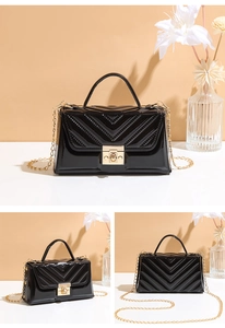 Detail of elegant black patent leather handbag with V-quilt stitching and gold metal lock