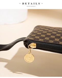 Close-up of brown leather handbag featuring gold vintage pattern and metallic zipper