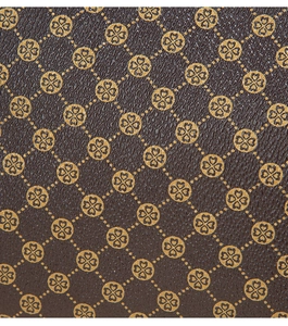 Detail of dark brown lychee leather texture with gold floral diamond pattern prints