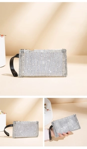 Detailed view of silver rhinestone clutch bag with black wrist strap and gold zipper