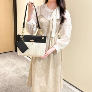 Elegante zweifarbige Tragetasche mit Flamingo-Beschlägen und kleinem Beutel am Modell