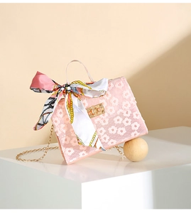 Detail of pink floral lace handbag with gold twist lock and printed silk scarf handle