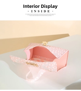 Detail view of pink lace crossbody bag showing gold T-lock and spacious interior