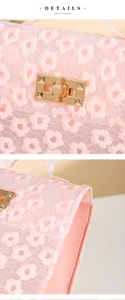 Detailed macro view of pink daisy lace embroidery and golden twist lock on handbag