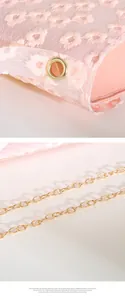 Close-up of pink floral embroidery texture and gold chain strap on small crossbody bag