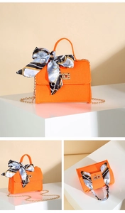 Detailed views of orange felt handbag with decorative silk scarf and gold metal hardware