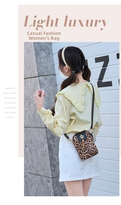 Detail of leopard print crossbody phone bag with gold crown buckle and elegant tassel