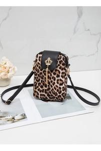 Detail of leopard print crossbody bag with golden crown charm and black tassel