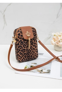 Close-up of leopard print crossbody bag with gold crown charm and tassel detail