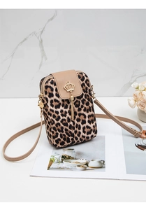 Detail view of leopard print crossbody bag with gold crown charm and metal tassels