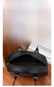 Internal storage detail of pebbled leather tote bag showing capacity for phone and makeup