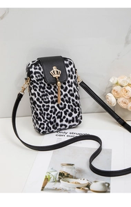 Close-up of leopard print crossbody bag with gold crown charm and metal tassel details