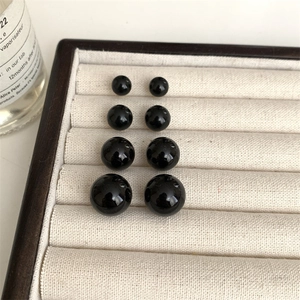 Set of four black round stud earrings in graduated sizes with a mirror polished finish