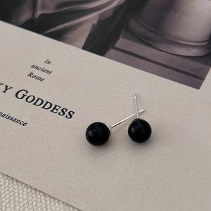 Close-up of S925 sterling silver studs with elegant black spherical pearls