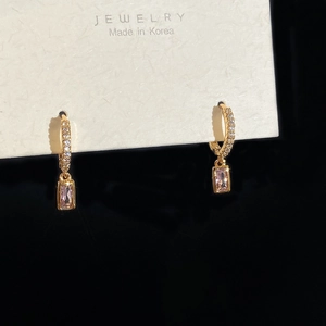 Detail of gold-plated hoop earrings with pink rectangular zircons on jewelry card