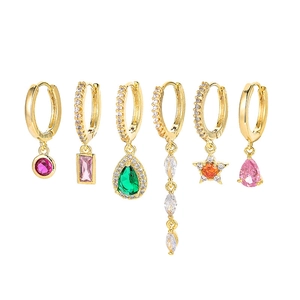 Set of 6 gold earrings with colorful zircon pendants in various shapes on white background