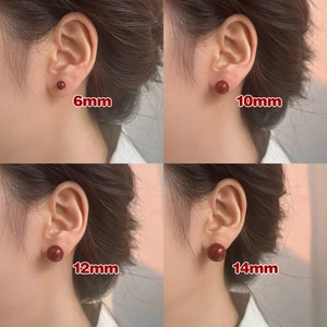 Comparación de pendientes de bola roja de 6mm a 14mm mostrados puestos en la oreja