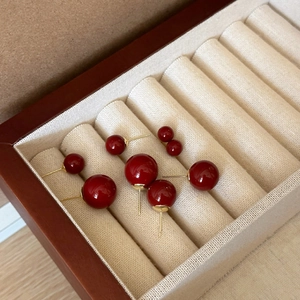 Elegantes pendientes de perlas rojas con pasadores dorados en varios tamaños