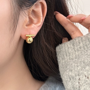 Elegant gold spherical bar earrings with minimalist geometric design shown on model