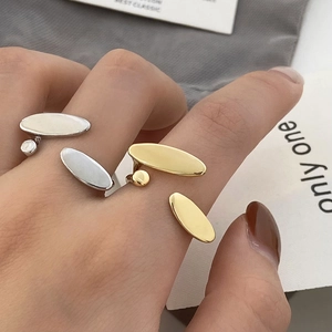 Detailed view of minimalist gold and silver open rings with oval geometric design