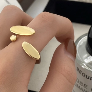 Detail of gold-plated adjustable ring featuring minimalist triple oval design on hand