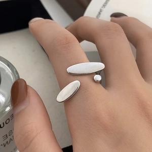Modern silver adjustable ring featuring three oval shell inserts on a person's hand