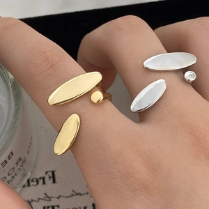 Detail shot of a minimalist gold ring and an asymmetrical silver ring with mother of pearl