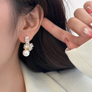 Détail de boucles d'oreilles perles et zircons portées par un mannequin au style chic