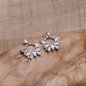 Gros plan de boucles d'oreilles étoiles avec cristaux de zircon sur socle en bois naturel