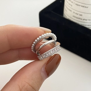 Gros plan sur un protège-oreille en argent avec perles et zircones à trois couches