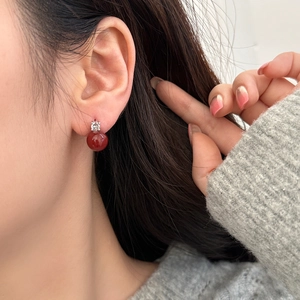 Elegant French luxury red pearl stud earrings with zircon stones on female model