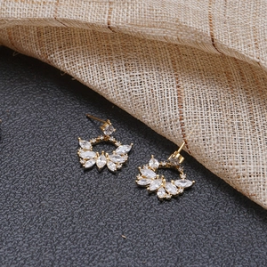 Élégantes boucles d'oreilles dorées en éventail avec cristal et zircons sur fond gris