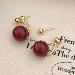 Macro shot of French vintage red pearl earrings with detachable gold plated curved hooks