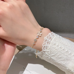 Elegant gold flower bracelet with cat eye stone and sparkling crystals on model wrist
