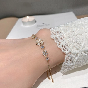 Elegant gold flower bracelet with cat eye petals and sparkling crystals on adjustable chain